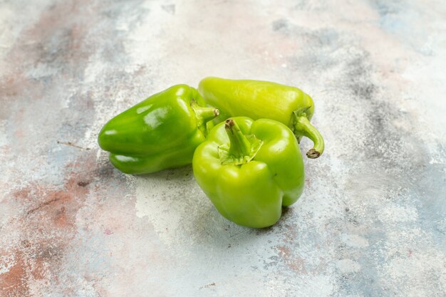 Front view green peppers on nude background with free space