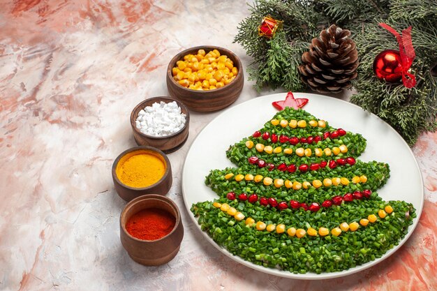 Free photo front view green salad in new year tree shape with seasonings on light background