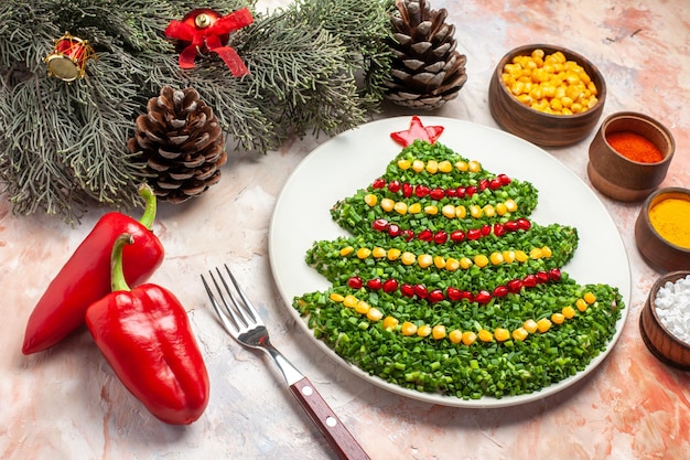 Free photo front view green salad in new year tree shape with seasonings on light desk