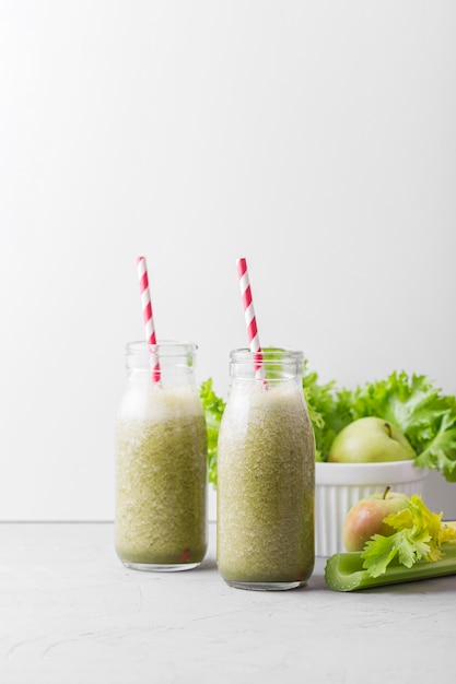 Free photo front view green smoothie bottles with copy space