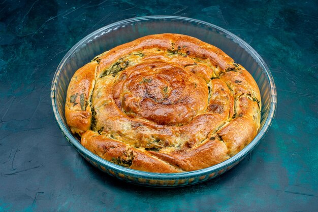 Front view greeny pastry with greens inside on dark background.