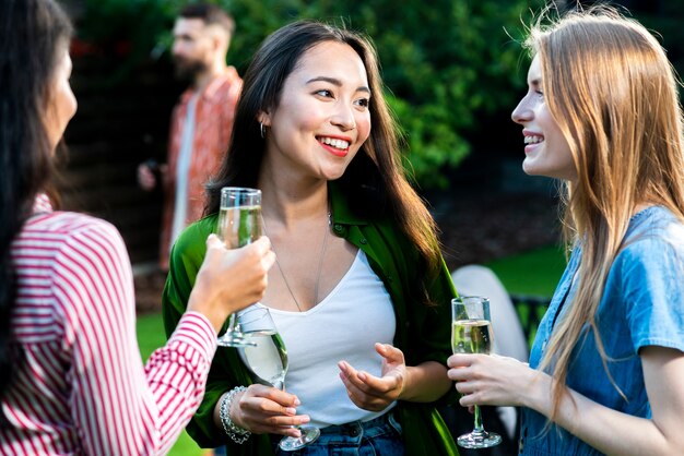 Front view group of girls socializing with drinks