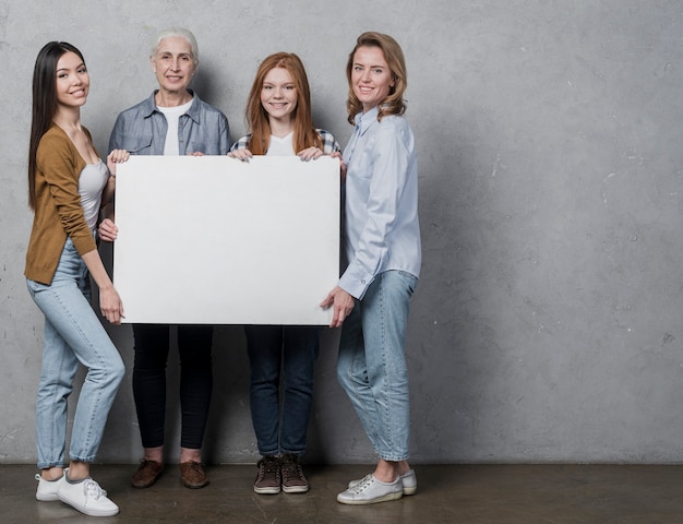 Foto gratuita gruppo di vista frontale di donne con un cartello