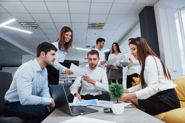 Front view. Group of young freelancers in the office have conversation and smiling