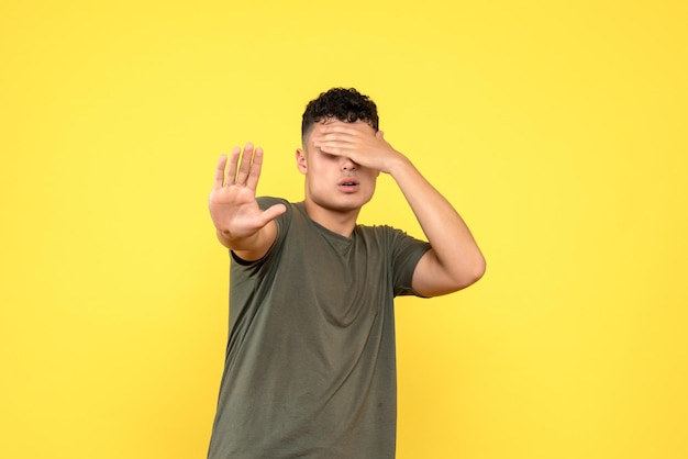 Foto gratuita la vista frontale del ragazzo si coprì il viso con la mano e tese la mano