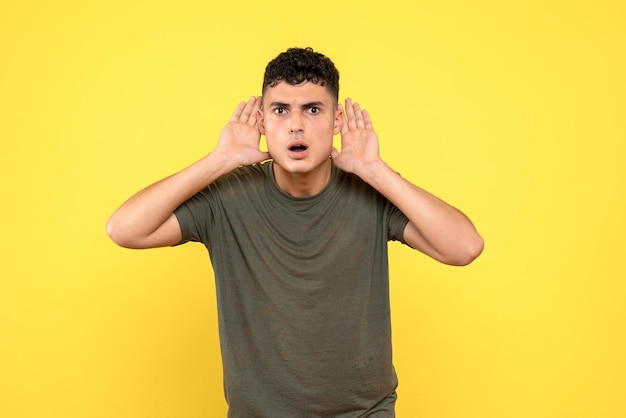 Free photo front view of a guy holds his hands near his ears to learn about the secret