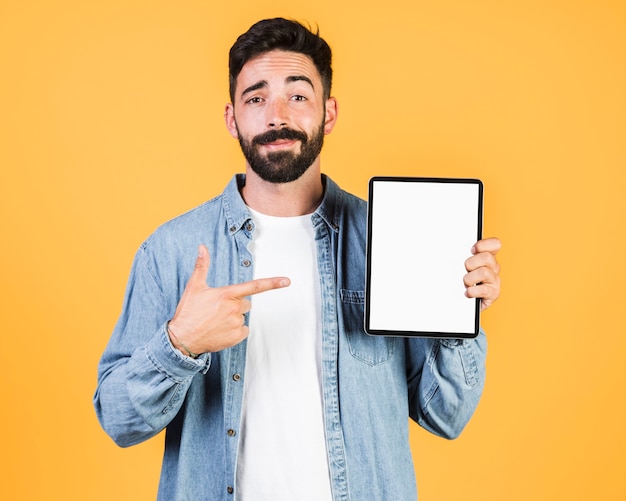 Front view guy pointing at a tablet