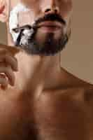 Free photo front view hairy man shaving beard