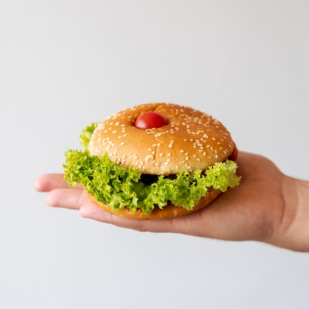 Free photo front view hamburger held by person