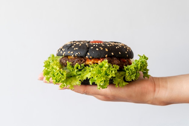 Free photo front view hamburger held by person