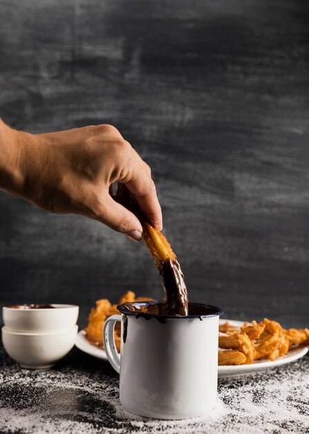 Front view hand dipping into a mug of chocolate