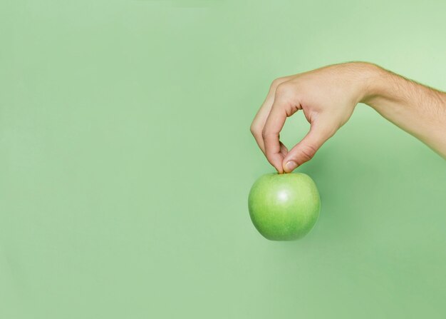 Front view of hand holding apple