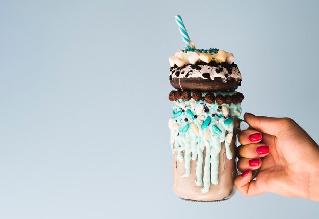 Front view of a hand holding a delicious milkshake