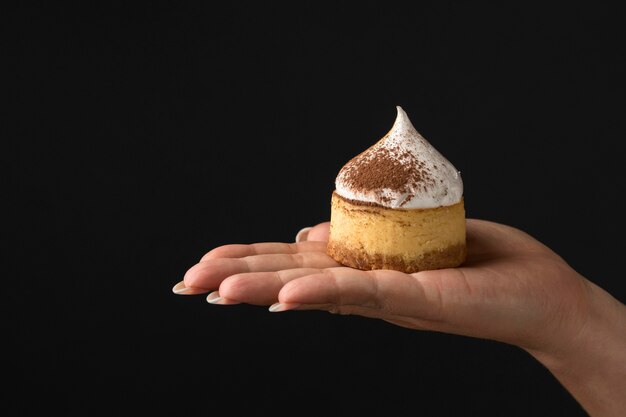 Front view of hand holding dessert with powdered cocoa