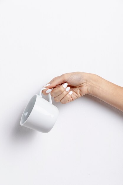 Front view of hand holding empty mug