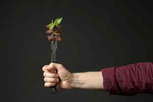 Free photo front view of hand holding food on fork