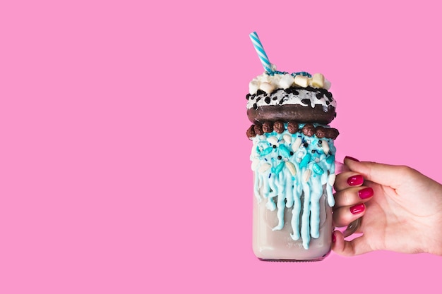 Front view of a hand holding a mug with milkshake