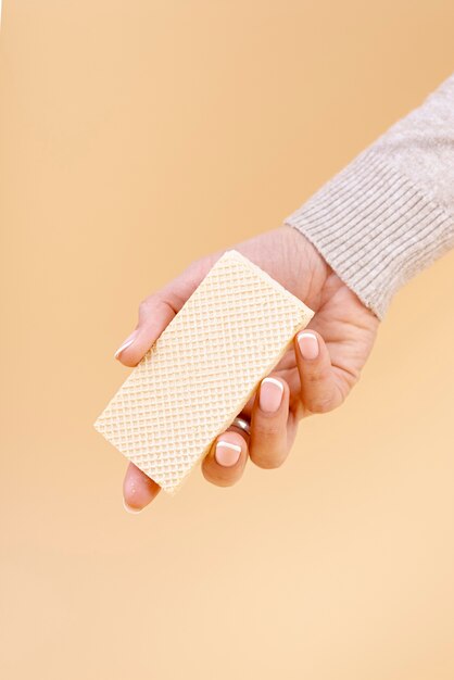 Front view of hand holding one piece of wafer with copy space