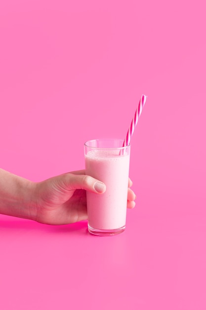 Front view hand holding pink smoothie with copy-space