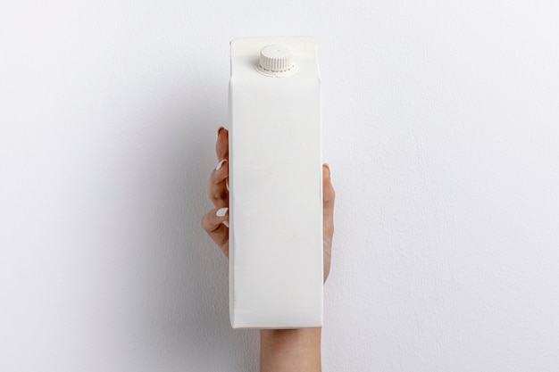 Front view of hand holding simple milk carton