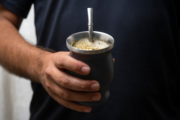 Free photo front view hand holding yerba mate