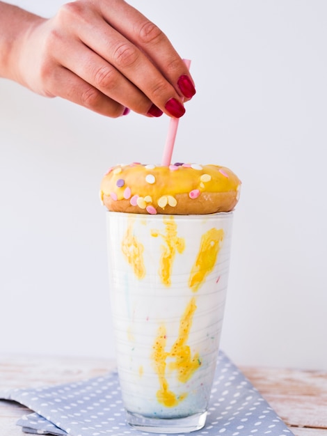 Front view of hand and milkshake on wooden table