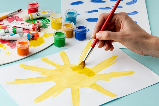 Front view of hand painting a sun