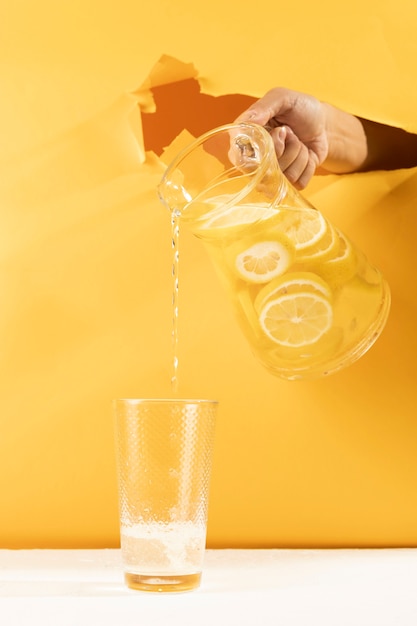 Front view hand pouring lemonade