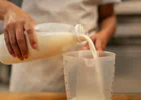 Free photo front view hand pouring milk in cup