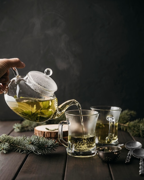 Front view hand pouring tea in glass