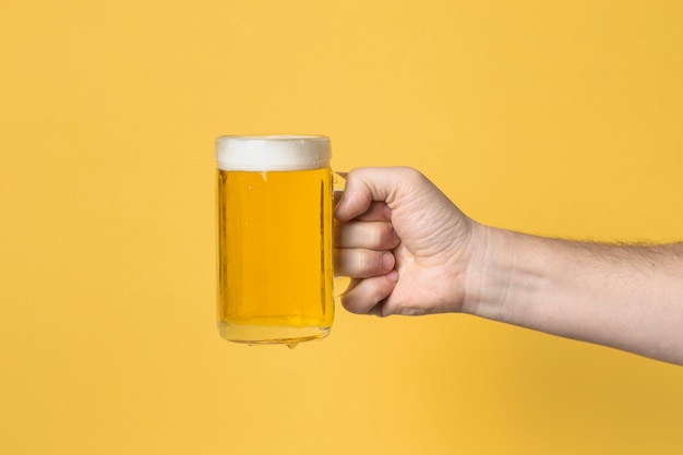 ビールジョッキを持つ正面図手 プレミアム写真