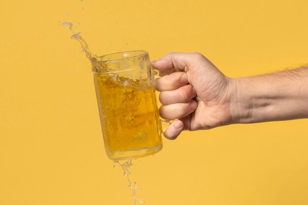 Front view hand with beer pint splash