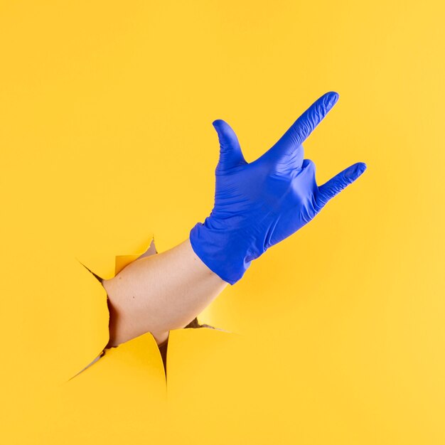 Front view of hand with surgical glove showing rock and roll gesture