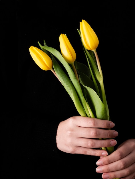 Front view hand with yellow tulips