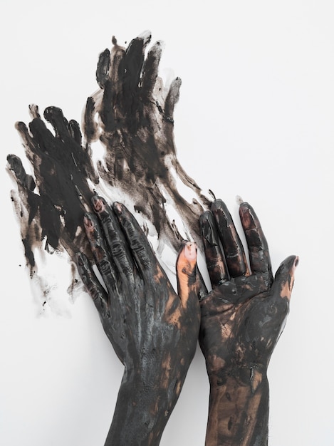 Front view of hands covered in black paint