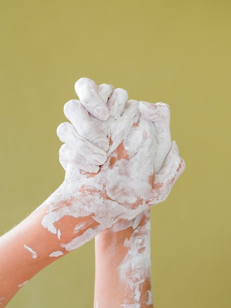 Free photo front view of hands covered in white paint