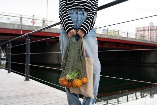 Front view hands holding bag with fruits