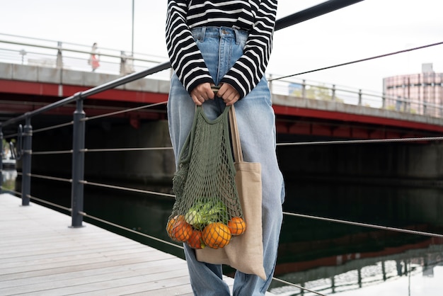 Front view hands holding bag with fruits