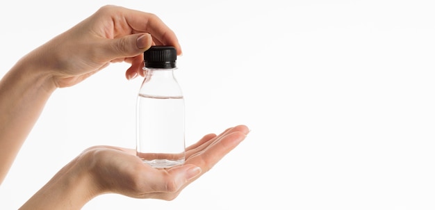 Front view of hands holding bottle of liquid