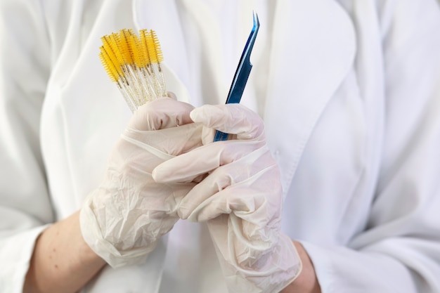 front view hands holding brushes and tweezers
