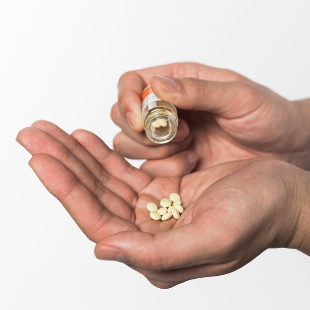 Front view of hands holding bunch of pills