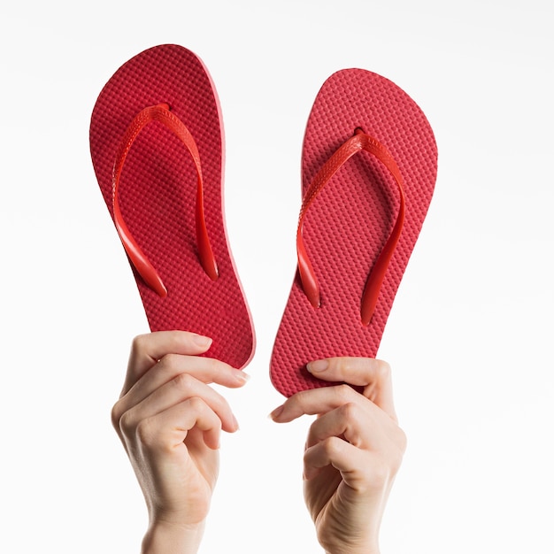 Front view of hands holding flip-flops