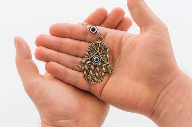 Front view of hands holding hamsa pendant