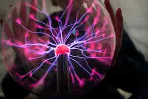 Free photo front view hands interacting  with a plasma ball
