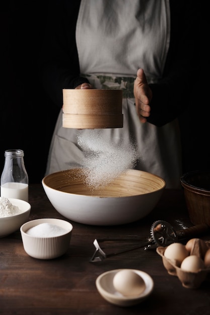 Free photo front view hands sifting flour