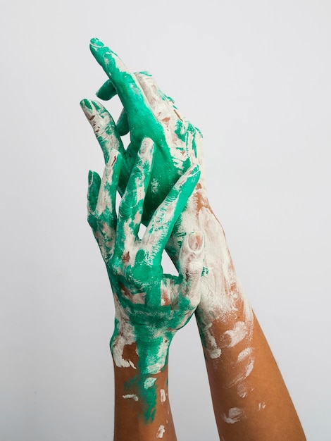 Front view of hands with paint over them