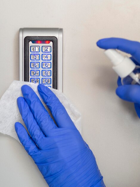 Foto gratuita vista frontale delle mani con guanti chirurgici dispositivo di disinfezione con tovagliolo