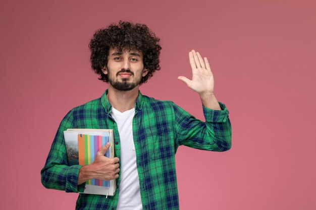 Front view handsome guy giving high five with notebooks