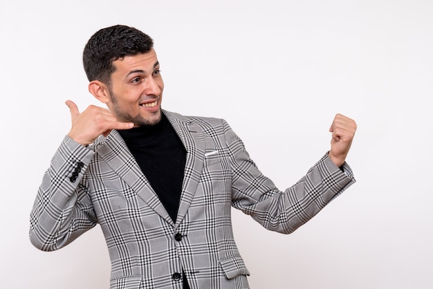 Front view handsome male in suit making call me sign standing on white background