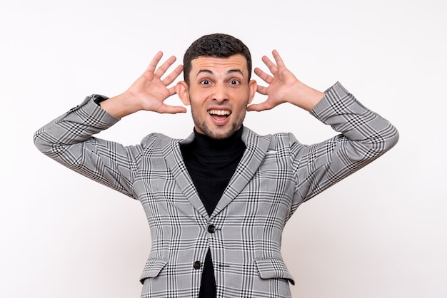 Front view handsome male in suit putting hands near ears standing on white background